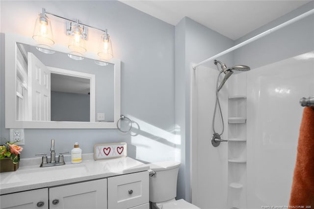 bathroom featuring a shower, vanity, and toilet