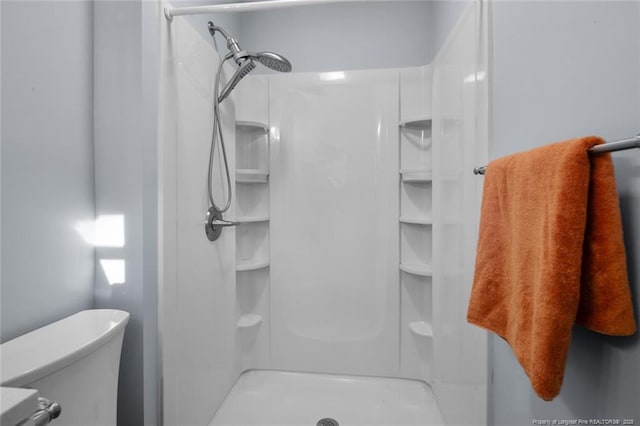 bathroom with a shower stall and toilet