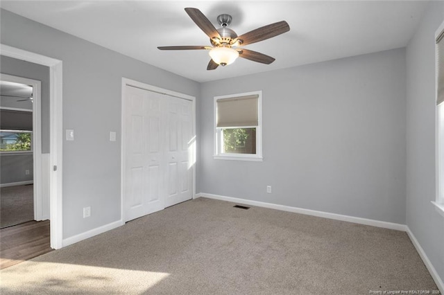 unfurnished bedroom with carpet flooring, a closet, visible vents, and baseboards