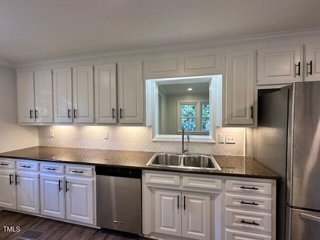 445 N Dunn St, Angier, NC 27501 - kitchen featuring appliances with stainless steel finishes, a sink, white cabinetry, dark wood-type flooring, and crown molding