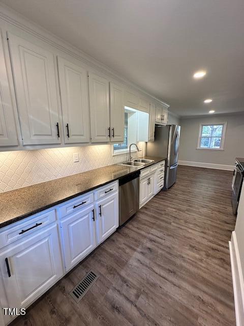 kitchen featuring white cabinetry, dark hardwood / wood-style flooring, sink, and appliances with stainless steel finishes