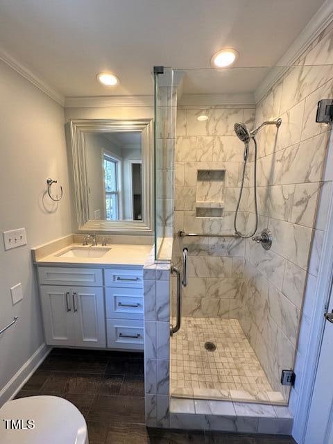 bathroom with vanity, a shower with door, toilet, ornamental molding, and wood-type flooring