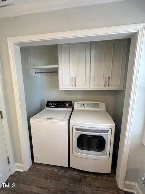 laundry area with cabinets, independent washer and dryer, and dark hardwood / wood-style floors