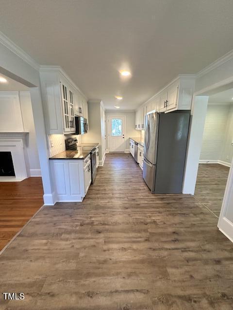 445 N Dunn St, Angier, NC 27501 - kitchen with stainless steel appliances, dark wood-style floors, baseboards, crown molding, and white cabinets