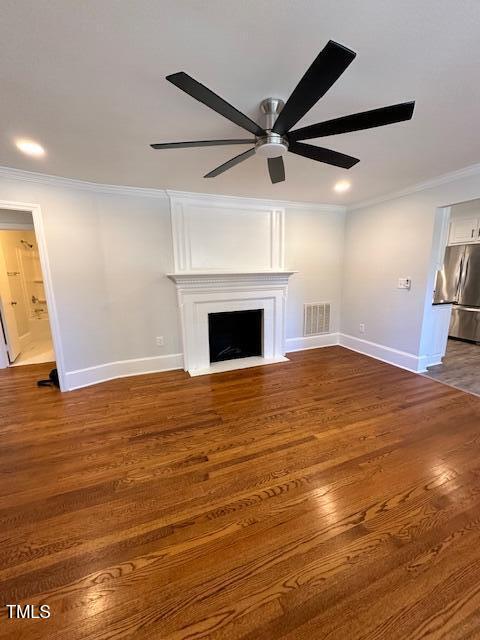 unfurnished living room featuring a fireplace, dark hardwood / wood-style flooring, ceiling fan, and crown molding