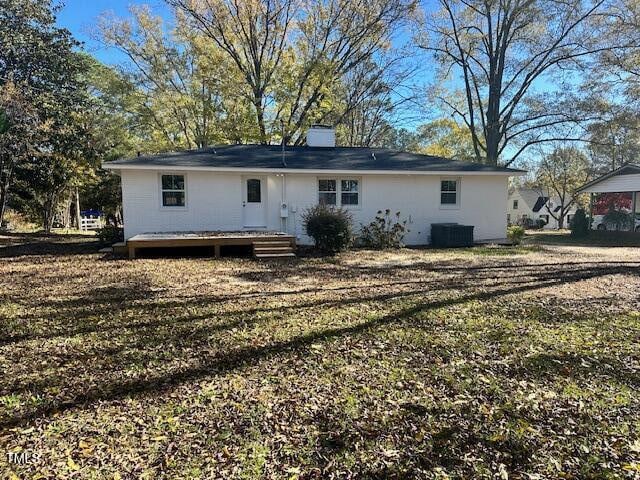 back of house with central air condition unit, a yard, and a deck