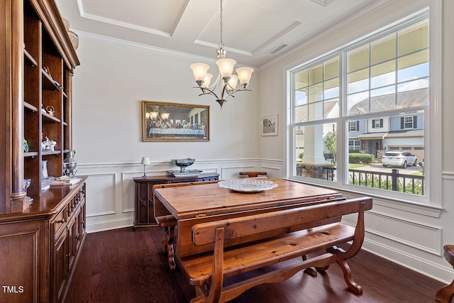 dining space with dark hardwood / wood-style flooring, an inviting chandelier, and crown molding