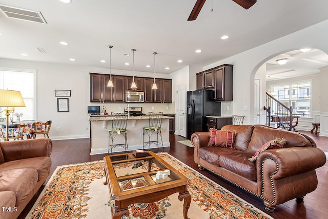 living room with ceiling fan and dark wood-type flooring