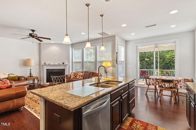 kitchen with sink, stainless steel dishwasher, plenty of natural light, and an island with sink