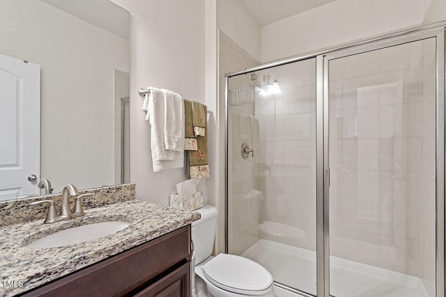 bathroom with vanity, toilet, and an enclosed shower