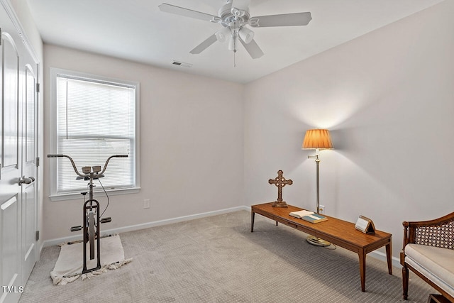 living area with light colored carpet, plenty of natural light, and ceiling fan