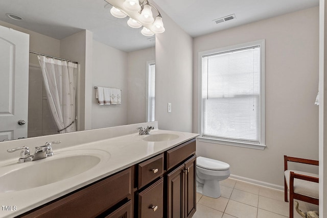 bathroom with tile patterned flooring, vanity, toilet, and plenty of natural light