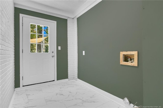 entryway featuring brick wall and ornamental molding