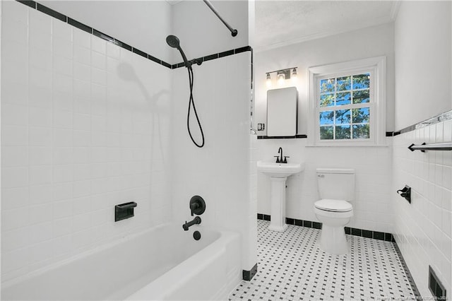 bathroom with toilet, ornamental molding, tile walls, and tiled shower / bath