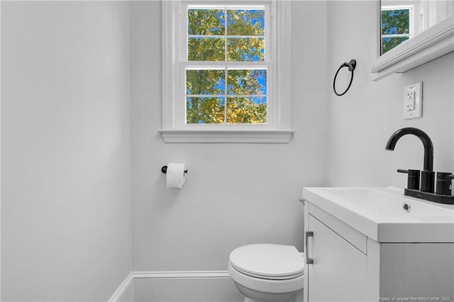 bathroom with plenty of natural light, vanity, and toilet