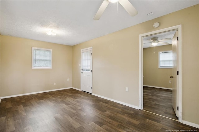 unfurnished room featuring dark hardwood / wood-style floors, a textured ceiling, and a wealth of natural light