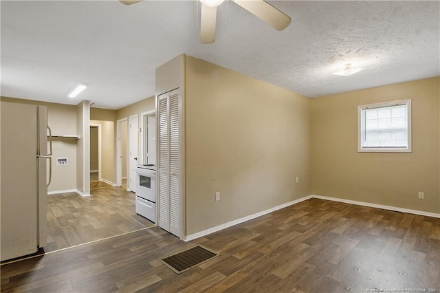 empty room with a textured ceiling, ceiling fan, and dark hardwood / wood-style floors