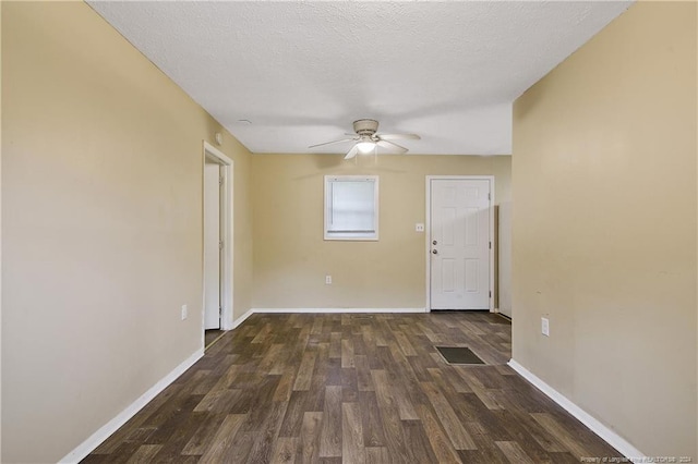 empty room featuring a textured ceiling, dark hardwood / wood-style floors, and ceiling fan