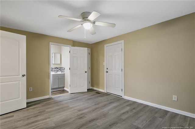 unfurnished bedroom featuring ceiling fan, ensuite bathroom, and light hardwood / wood-style flooring