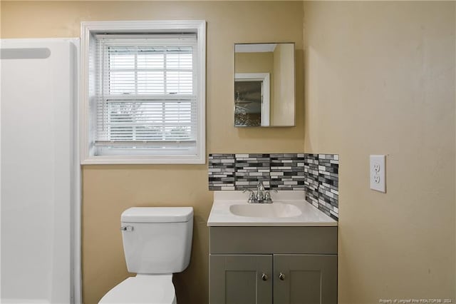 bathroom with backsplash, vanity, and toilet