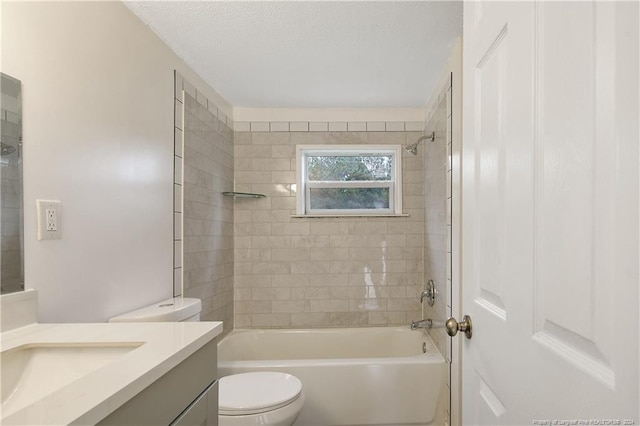 full bathroom with tiled shower / bath, vanity, and toilet