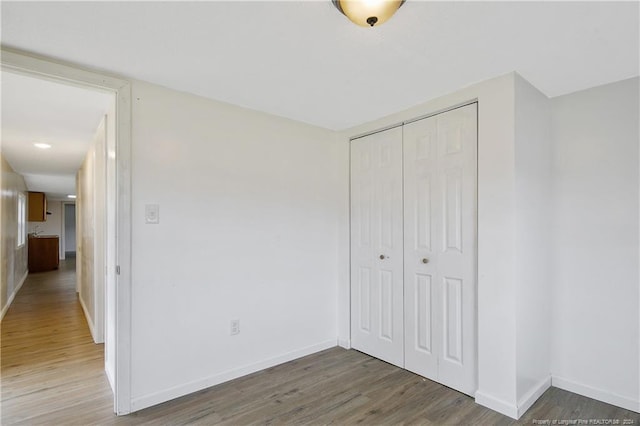 unfurnished bedroom featuring hardwood / wood-style floors and a closet