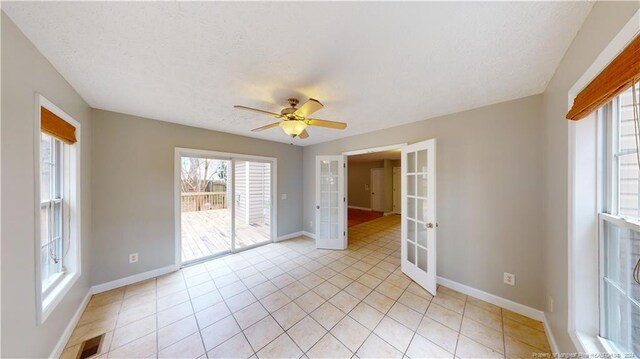 tiled spare room featuring french doors, a textured ceiling, and ceiling fan