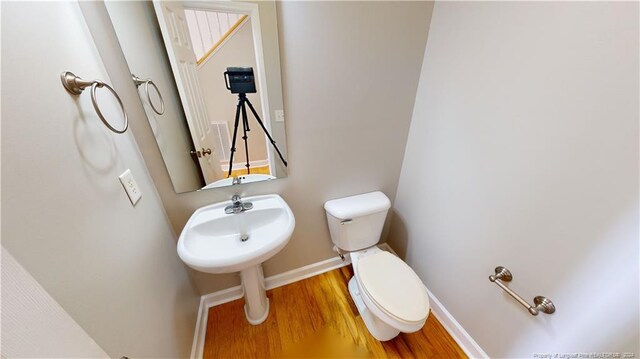 bathroom featuring hardwood / wood-style flooring and toilet