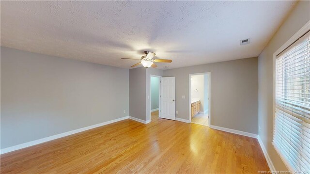 spare room featuring ceiling fan, light hardwood / wood-style floors, and a textured ceiling