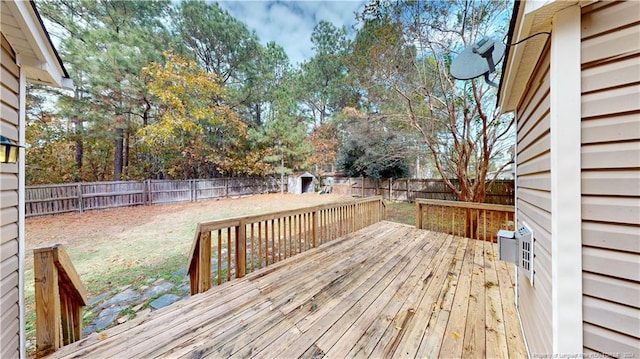 wooden deck featuring a lawn and a storage unit