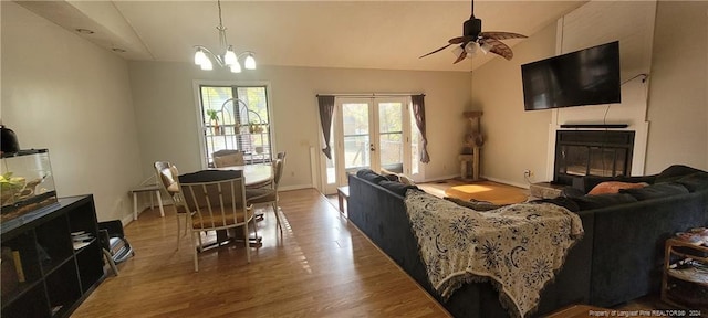 living room featuring hardwood / wood-style floors, ceiling fan with notable chandelier, and lofted ceiling