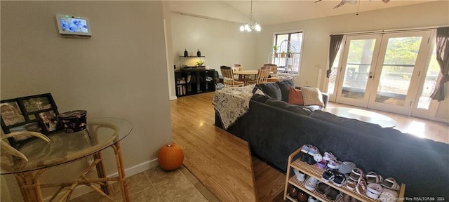 living room featuring french doors, light hardwood / wood-style flooring, a wealth of natural light, and vaulted ceiling