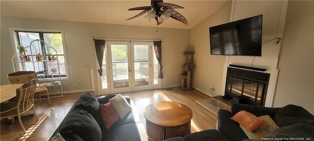 living room featuring a wealth of natural light, ceiling fan, vaulted ceiling, and hardwood / wood-style flooring