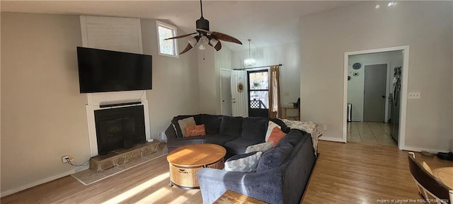 living room with hardwood / wood-style floors, high vaulted ceiling, ceiling fan, and a healthy amount of sunlight