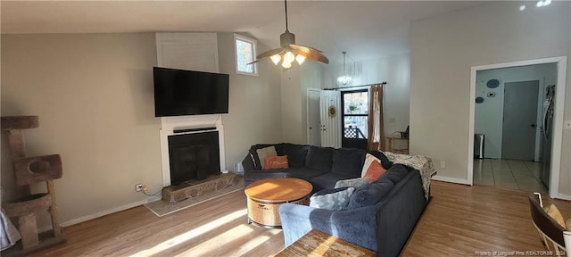 living room featuring wood-type flooring, vaulted ceiling, and ceiling fan