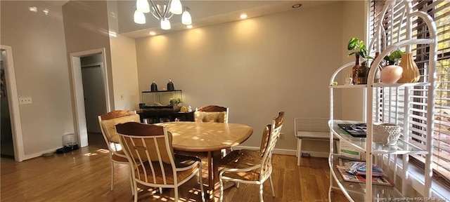 dining room featuring a chandelier, hardwood / wood-style floors, and a high ceiling