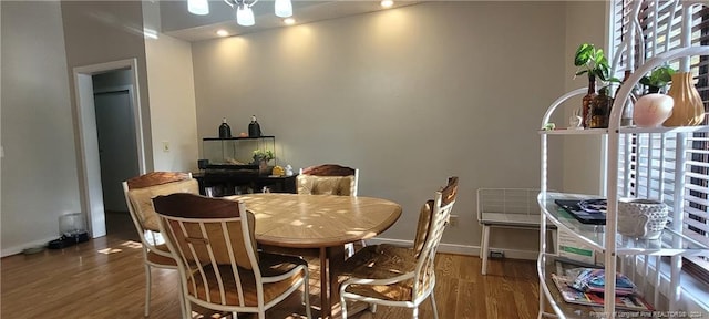 dining room with wood-type flooring and a notable chandelier