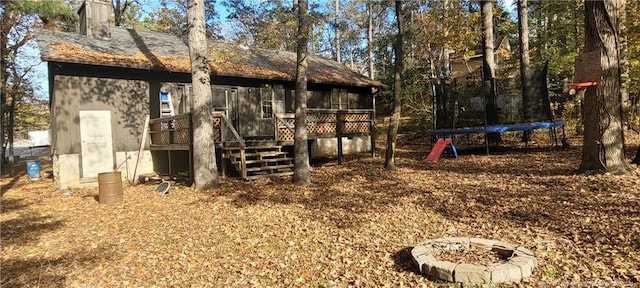 view of yard featuring a trampoline and a deck