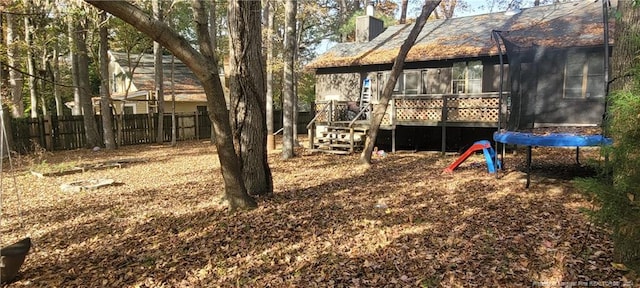 view of yard with a deck and a trampoline