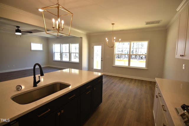 kitchen with visible vents, open floor plan, a sink, and ornamental molding