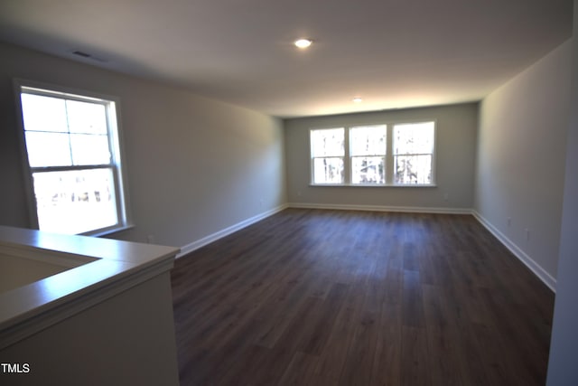 unfurnished room featuring visible vents, baseboards, dark wood-style flooring, and recessed lighting