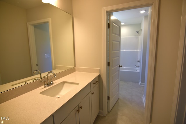 bathroom featuring tile patterned flooring, bathtub / shower combination, and vanity