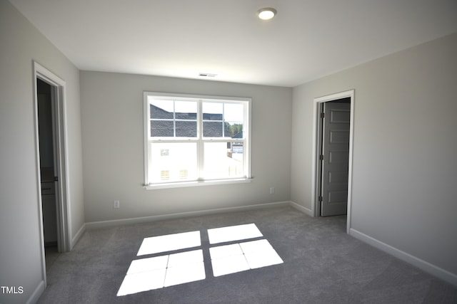 unfurnished bedroom featuring carpet, baseboards, and visible vents