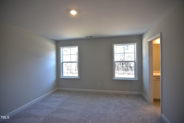 carpeted empty room with visible vents and baseboards