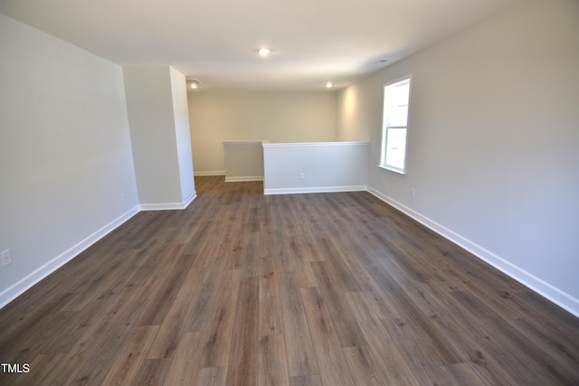 empty room with dark wood finished floors and baseboards