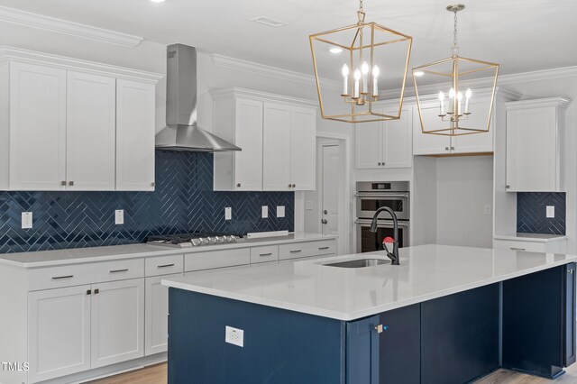 35 Accord Dr, Youngsville, NC 27596 - kitchen with wall chimney range hood, stainless steel appliances, white cabinets, a chandelier, and ornamental molding