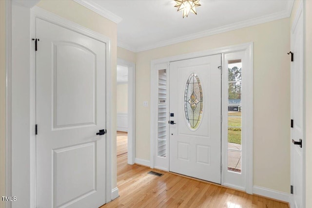 foyer entrance with light wood-type flooring and crown molding