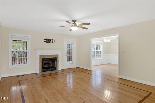 unfurnished living room with light hardwood / wood-style floors, ceiling fan, and a healthy amount of sunlight