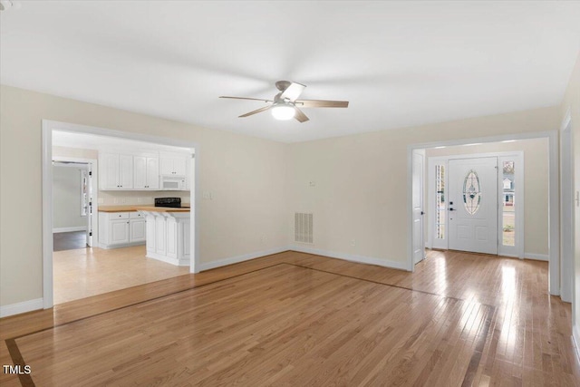 unfurnished living room with light hardwood / wood-style flooring and ceiling fan