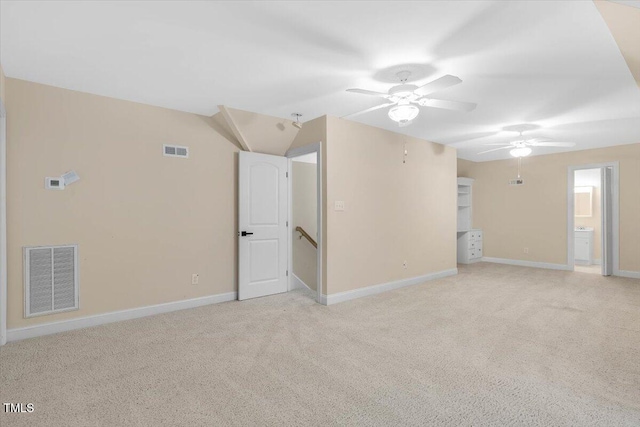 spare room featuring ceiling fan, light colored carpet, and lofted ceiling